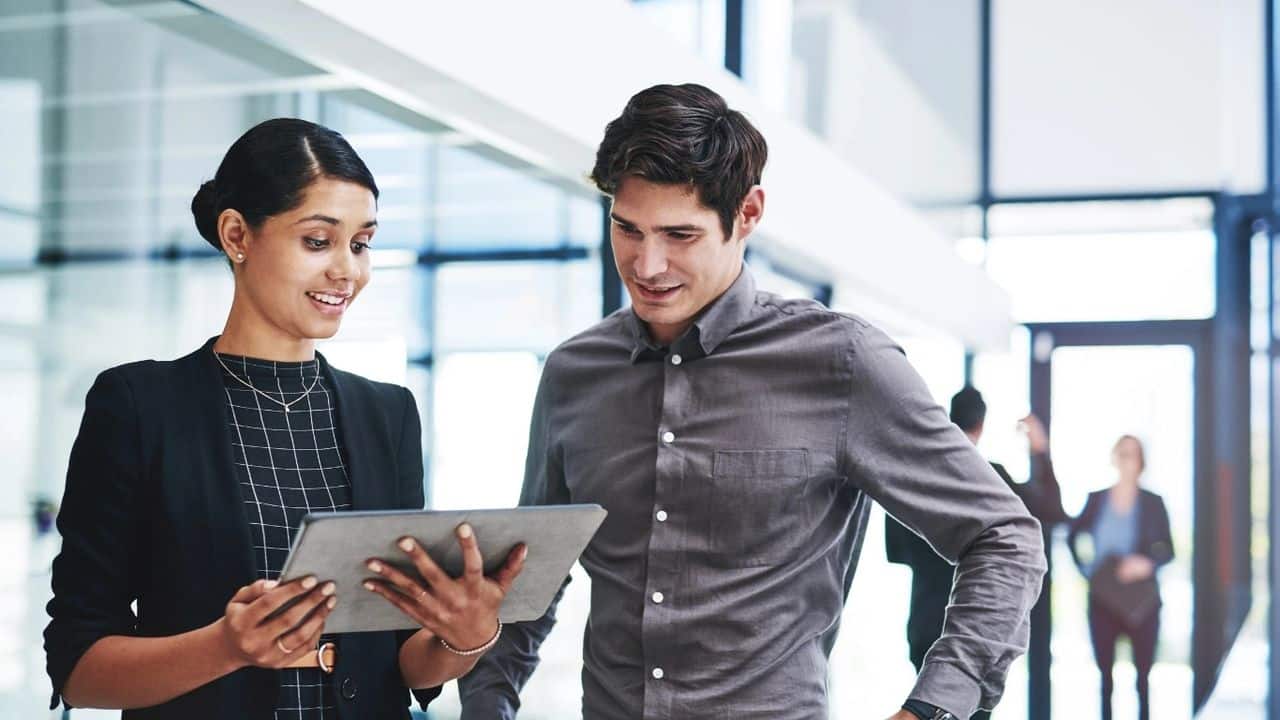How to use Your Honesty for Global Success, a woman showing her tablet screen to a male colleague